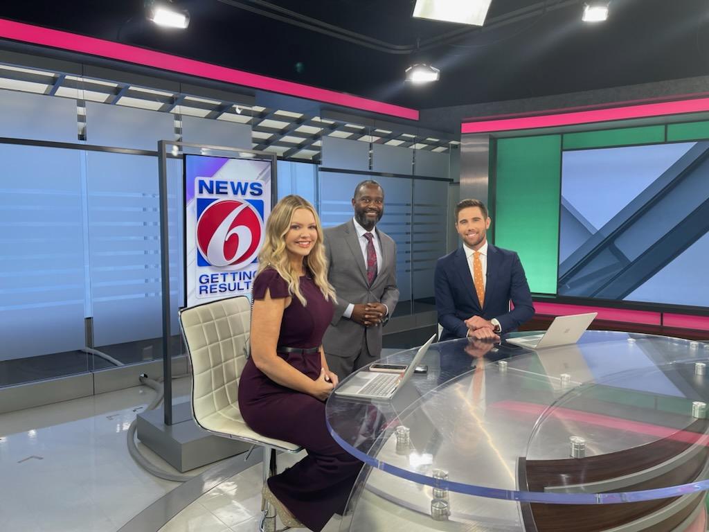 Dr. Duron Lee posing on news set with WKMG news anchors